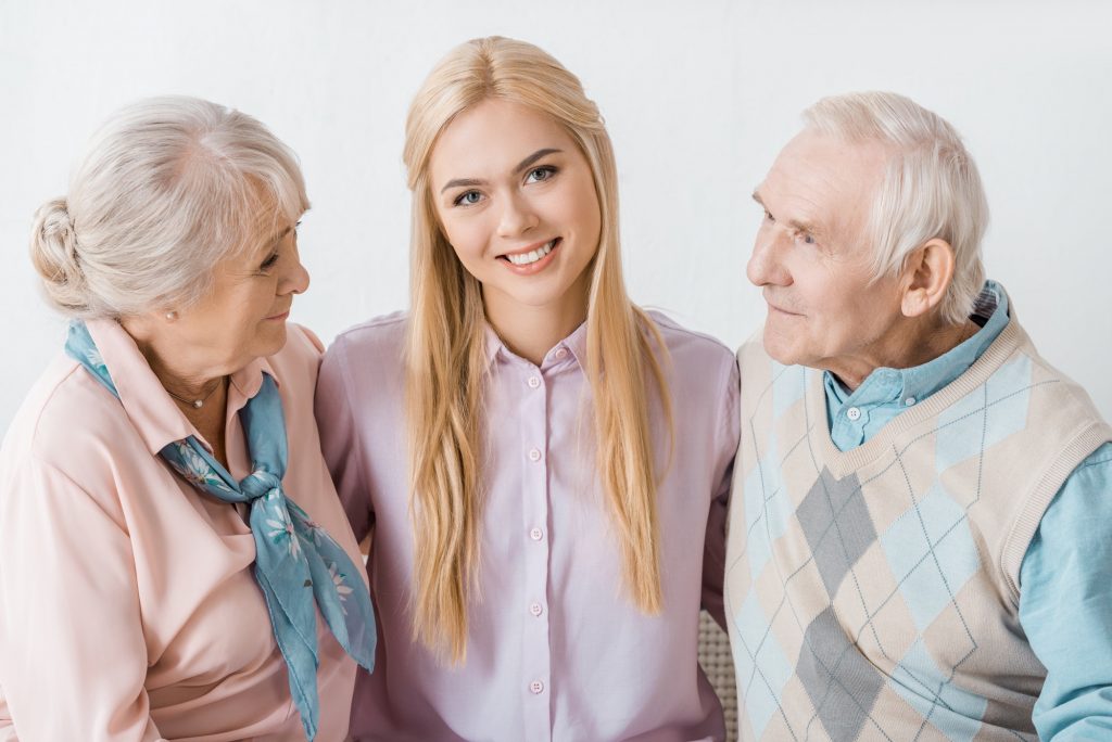 young smiling woman hugging senior parents